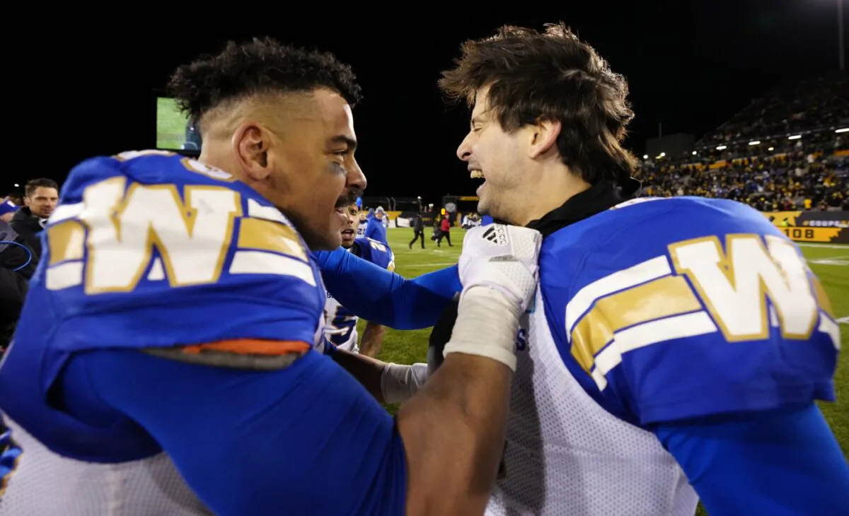 Winnipeg Blue Bombers running back Andrew Harris (33) celebrates with quarterback Zach Collaros (8) after they defeated the Hamilton Tiger-Cats in the 108th CFL Grey Cup in Hamilton, Ont., on Dec. 12, 2021. (The Canadian Press/Frank Gunn)