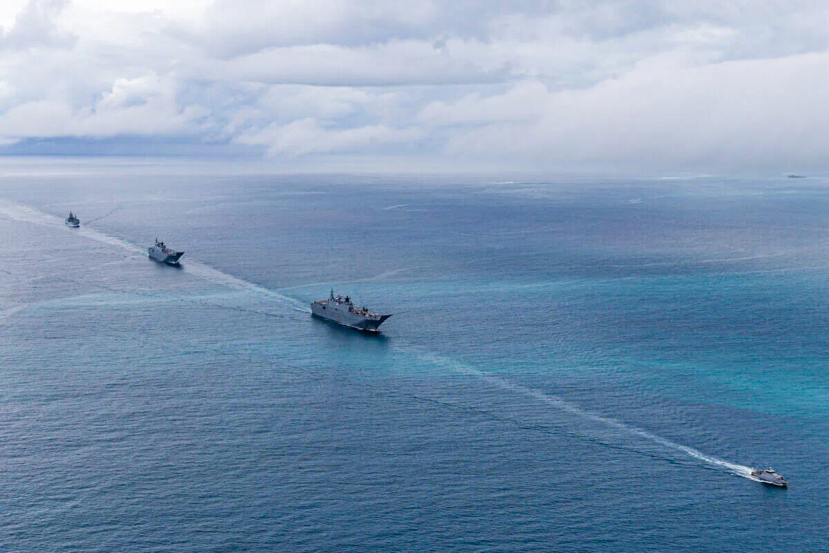 Royal Australian Navy ships HMAS Adelaide (centre), HMAS Canberra and HMAS Supply (left) are escorted into Nuku‘alofa harbour by the Tongan Navy Guardian-class patrol boat VOEA Ngahau Siliva (right) during Operation Tonga Assist 2022 on March 1, 2022. (LSIS David Cox via ADF)