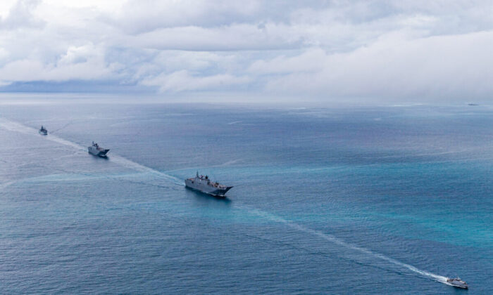 Royal Australian Navy ships HMAS Adelaide (centre), HMAS Canberra and HMAS Supply (left) are escorted into Nuku‘alofa harbour by the Tongan Navy Guardian-class patrol boat VOEA Ngahau Siliva (right) during Operation Tonga Assist 2022 on March 1, 2022. (LSIS David Cox via ADF)