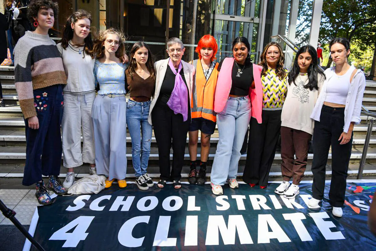 Eight high school students and their 87-year-old litigation representative, Sister Brigid Arthur stand outside the NSW Federal Court in Sydney, Australia, on March 15, 2022. The Federal Court full bench is set to rule on a finding that the Australian government has a duty of care to protect children against climate change. (AAP Image/Dean Lewins)