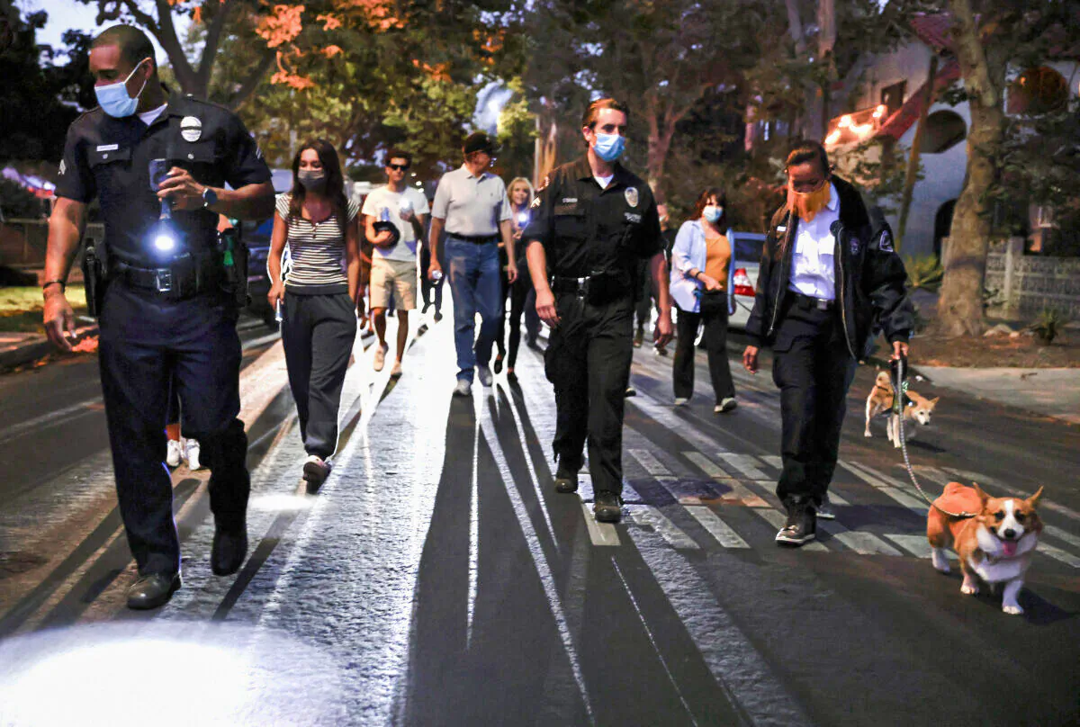 Los Angeles Police Department officers walk with community members in the Melrose area during an event to promote safety and police-community relationships in Los Angeles on Aug. 3, 2021. (Mario Tama/Getty Images)