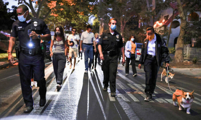 Los Angeles Police Department officers walk with community members in the Melrose area during an event to promote safety and police-community relationships in Los Angeles on Aug. 3, 2021. (Mario Tama/Getty Images)