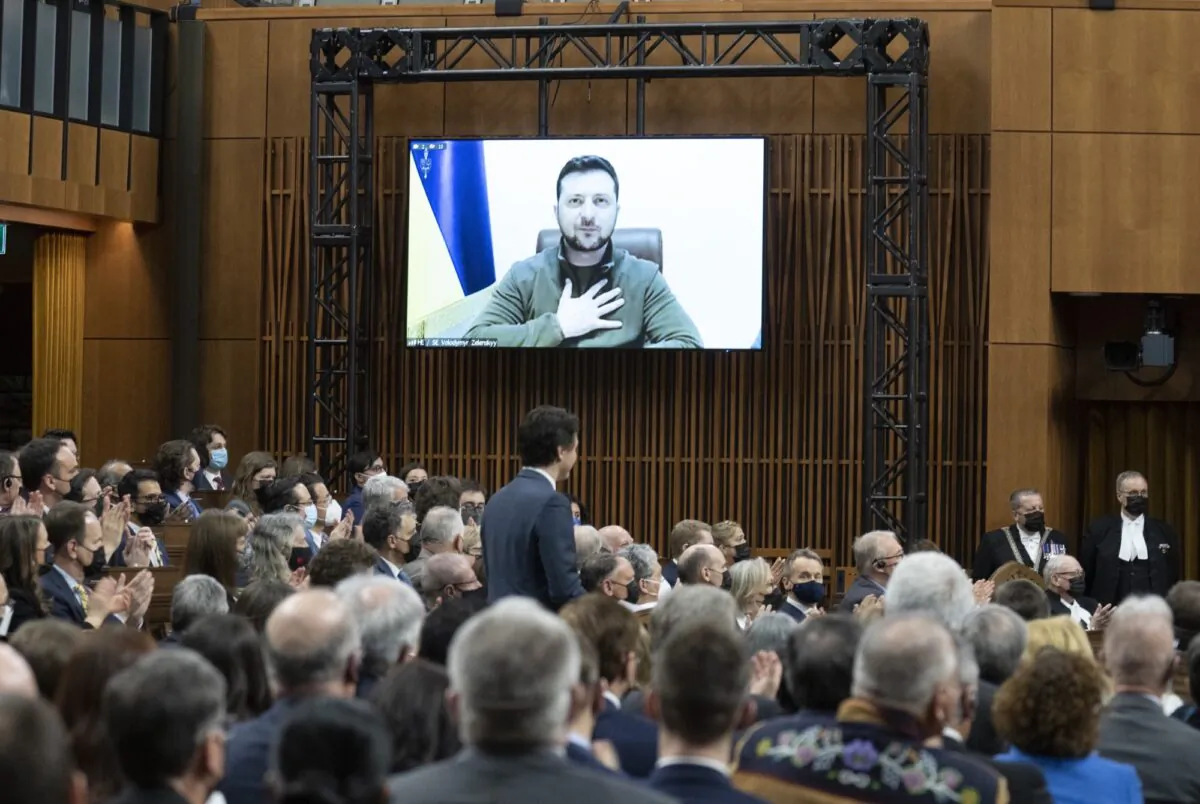 Ukrainian President Volodymyr Zelenskyy places his hand on his chest as he listens to Canadian Prime Minister Justin Trudeau deliver opening remarks before addressing the Canadian parliament, on March 15, 2022 in Ottawa. (Adrian Wyld/The Canadian Press)