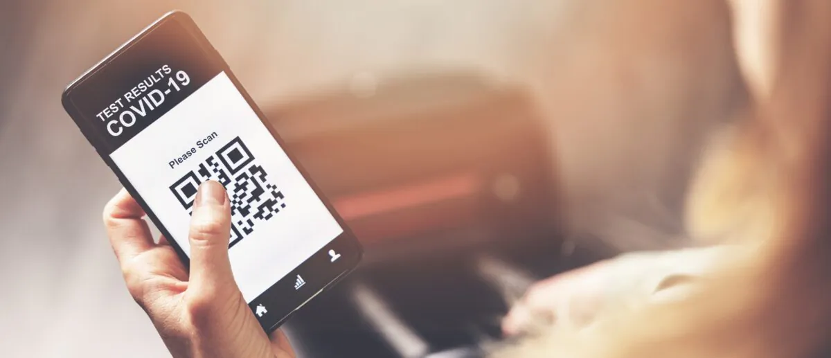 Woman using mobile phone application with COVID-19 test results in airport. (Dreamstime)