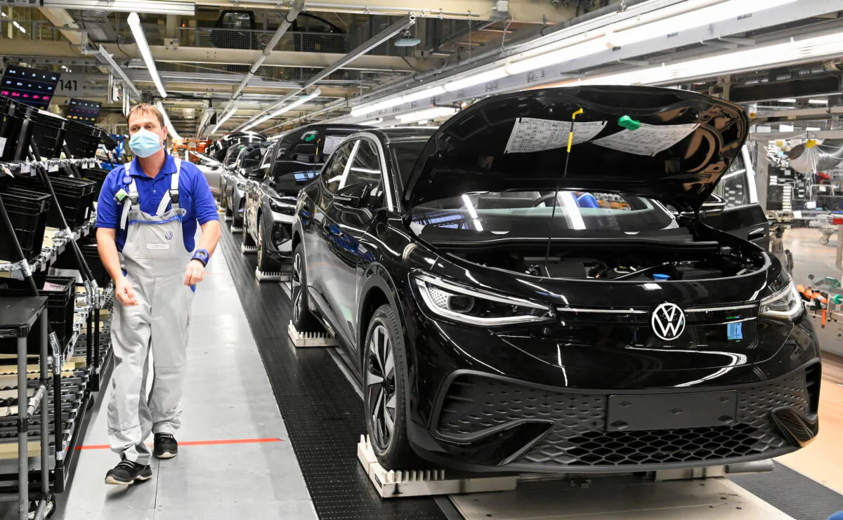 A technical employee works at the production line for the electric Volkswagen model ID.5 car in Zwickau, Germany, on Jan. 27, 2022. (Matthias Rietschel/Reuters)