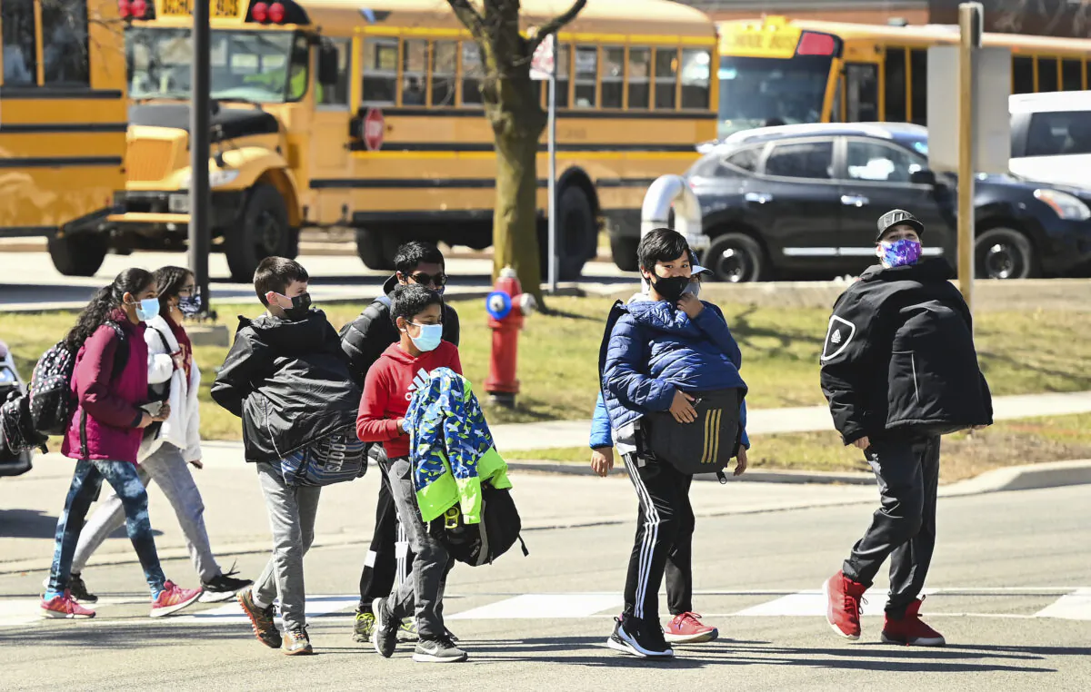 Masked students cross the street in Mississauga, Ont., on April 1, 2021.  (The Canadian Press/Nathan Denette)