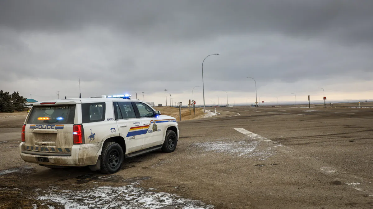 A police vehicle looks out over an empty highway in Coutts, Alberta, on Feb. 15, 2022. (The Canadian Press)