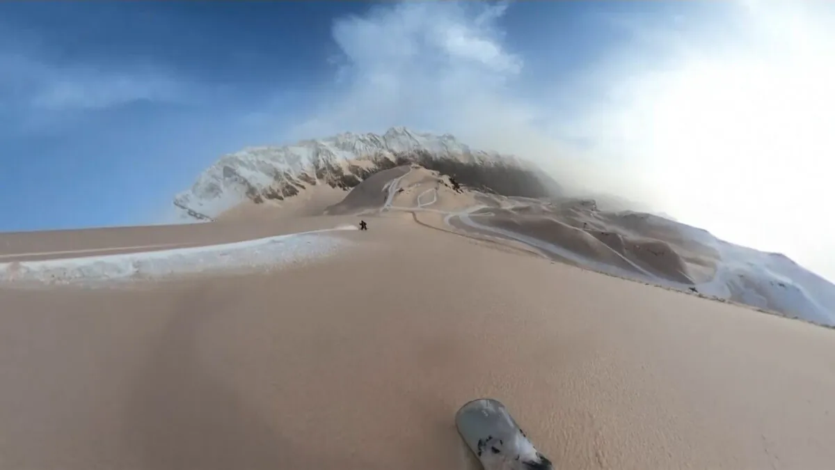 Snowboarder Sam Esteve carves through dusty snow, leaving bright white trails, in the Piau Engaly ski station in the French Pyrenees, on March 15, 2022, in a still from a video. (Sam Esteve/UGC/via AP/Screenshot via The Epoch Times)