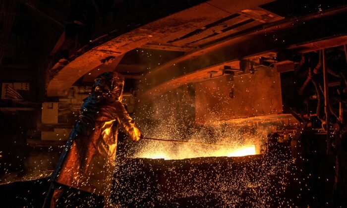 This picture taken on March 30, 2019 shows a worker manning a furnace during the nickel smelting process at Indonesian mining company PT Vale's smelting plant in Soroako, South Sulawesi. (Bannu Mazandra/AFP via Getty Images)
