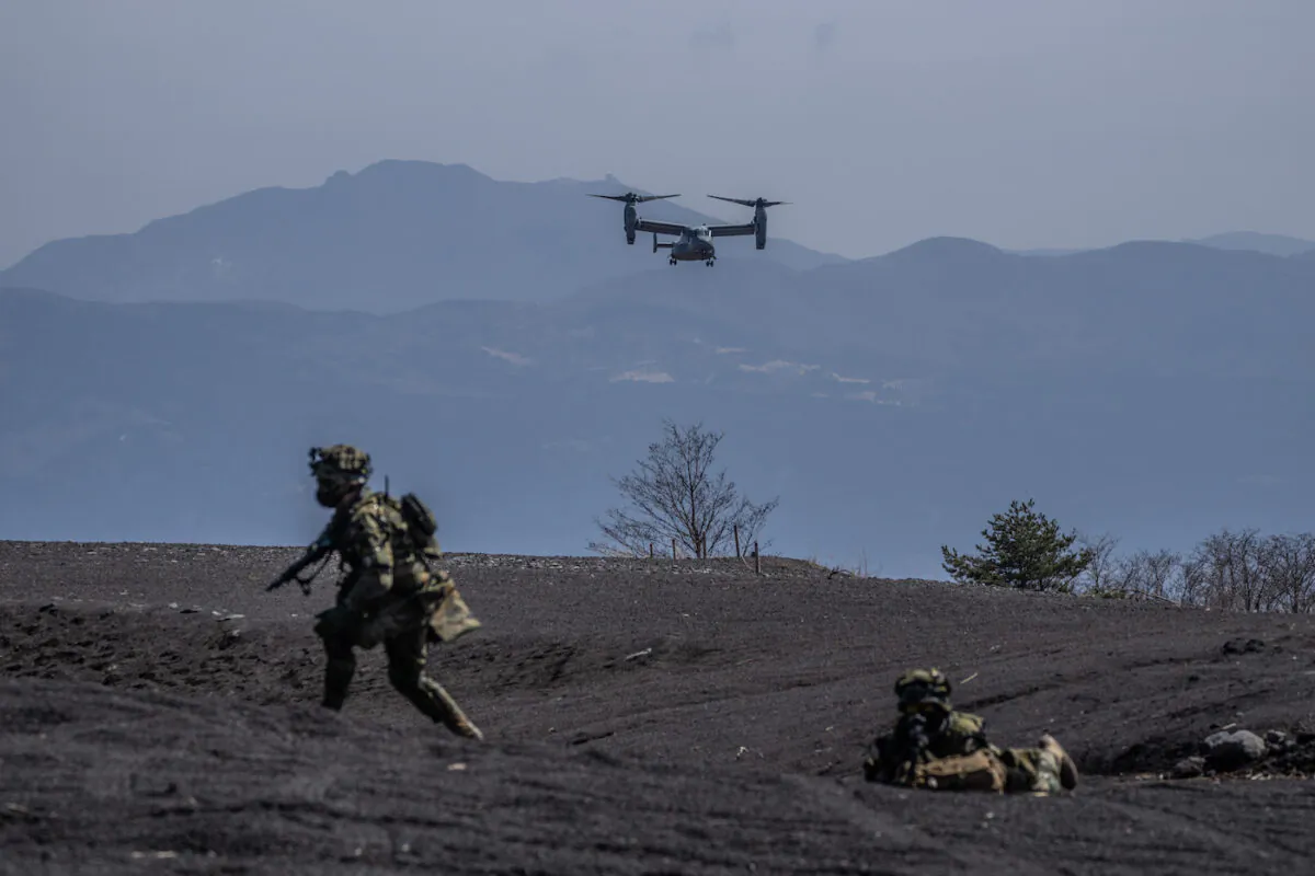 A U.S. Marine Corps' Osprey is about to land next to soldiers from Japan's 1st Amphibious Rapid Deployment Brigade during an exercise with the U.S. 31st Marine Expeditionary Unit in Gotemba, Japan, on March 15, 2022. (Carl Court/Getty Images)