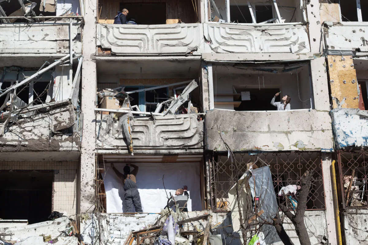 People examine the damage to a residential building in Mostytska Street which got hit by a rocket in Kyiv, Ukraine, on March 15, 2022. (Anastasia Vlasova/Getty Images)