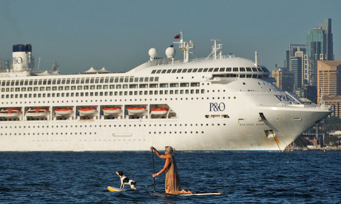 A woman paddle boards with her dog as P&O's Pacific Dawn is moored in Sydney Harbour in Sydney, Australia on November 25, 2015 . (Photo by Brendon Thorne/Getty Images)