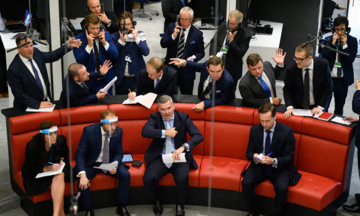 Traders, brokers and clerks shout and gesture on the first day of in-person trading at the London Metal Exchange (LME) on Sept. 6, 2021. (Leon Neal/Getty Images)