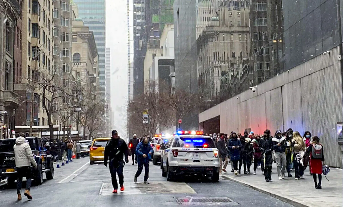 In this photo from a social media post by Scott Cowdrey, people are evacuated from the Museum of Modern Art  in N.Y.C. where a stabbing occurred on March 12, 2022. (Scott Cowdrey via AP)