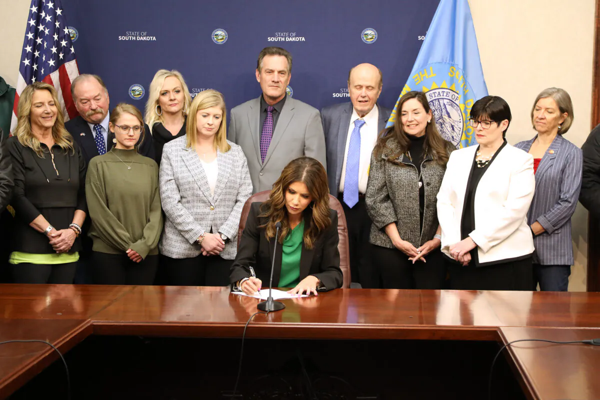 South Dakota Gov. Kristi Noem signs a bill into law banning outside spending on elections, in Pierre, S.D., on March 16, 2022. (Courtesy of the Office of the South Dakota Governor)
