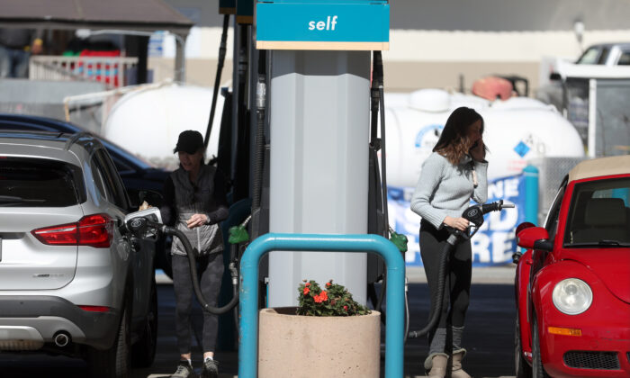 Customers pump gas into their cars at a gas station in Mill Valley, Calif., on Feb. 23, 2022. (Justin Sullivan/Getty Images)
