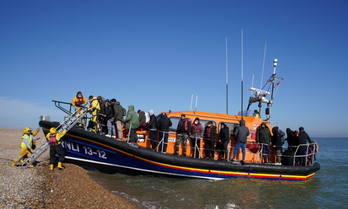 A group of people brought ashore by the RNLI following a small boat incident in the English Channel are brought to Dungeness, Kent, England, on March 15, 2022. (Gareth Fuller/PA)