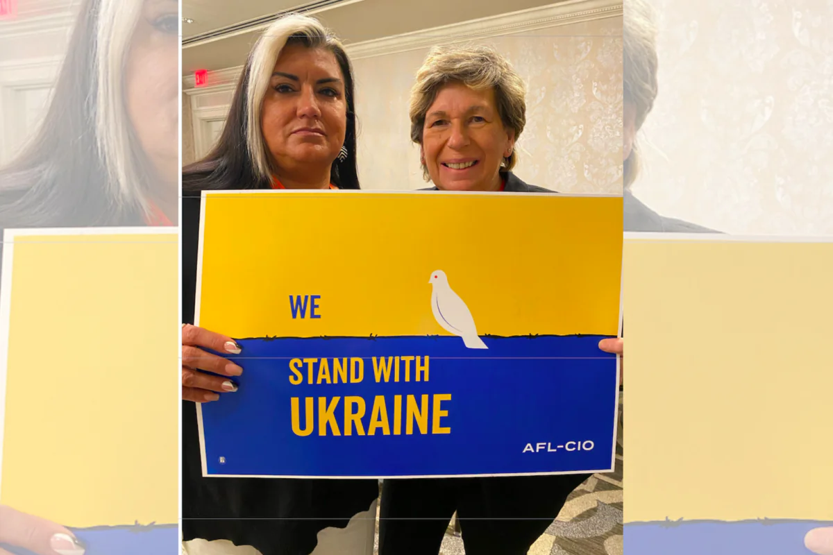 AFT President Randi Weingarten and Executive Vice President Evelyn DeJesus pose with a poster that mistakenly placed Ukraine's national colors in reverse. (Twitter)