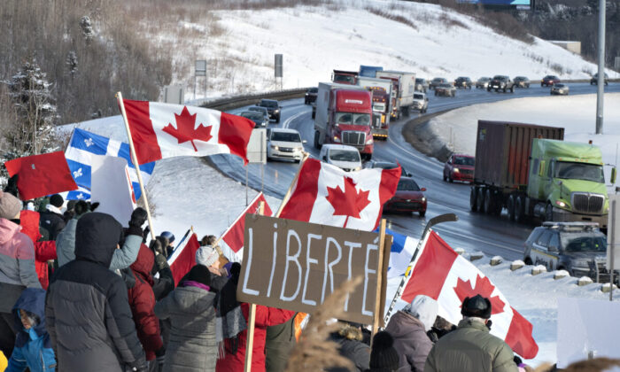 Hundreds of people gather by TransCanada Highway 20 to show their support to truckers heading to Ottawa to protest against COVID-19 restrictions, in Levis, Quebec, on Jan. 28, 2022. (Jacques Boissinot/The Canadian Press)
