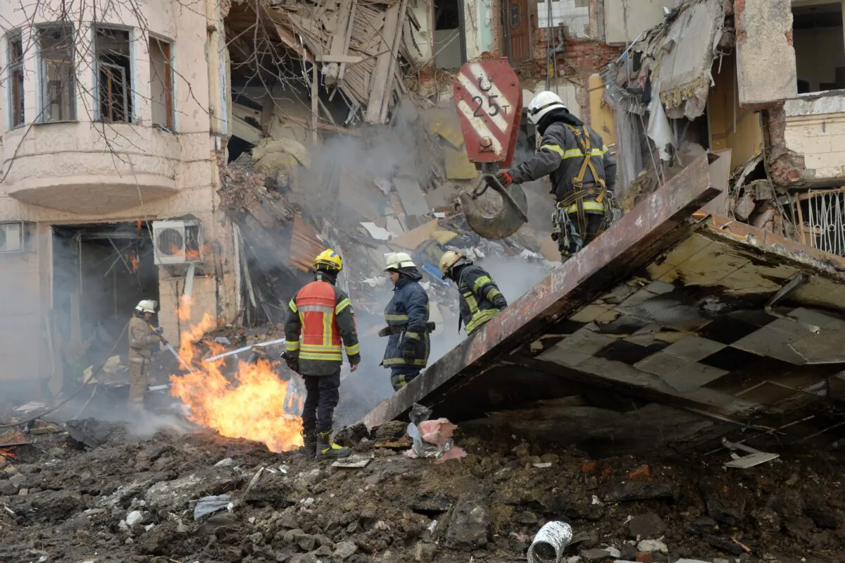 Firemen work to clear the rubble and extinguish a fire by a heavily damaged building after a Russian rocket exploded just outside it in Ukraine's second city Kharkiv on March 14, 2022. (Sergey Bobok/AFP via Getty Images)