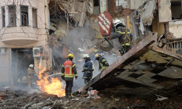 Firemen work to clear the rubble and extinguish a fire by a heavily damaged building after a Russian rocket exploded just outside it in Ukraine's second city Kharkiv on March 14, 2022. (Sergey Bobok/AFP via Getty Images)