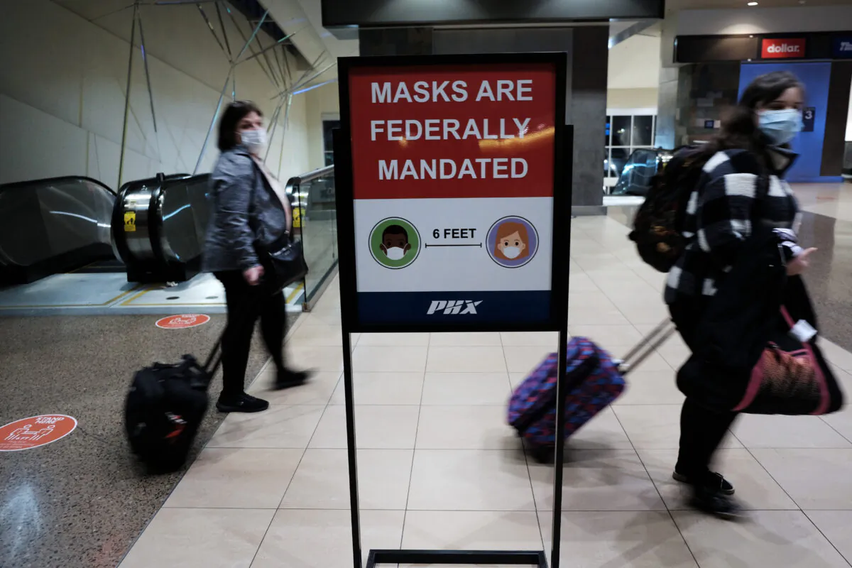 People walk through Sky Harbor International Airport in Phoenix where new COVID-19 cases are down but health experts warn cases may rise with the introduction of the omicron strain in Phoenix, Arizona, on Dec. 18, 2021. (Spencer Platt/Getty Images)