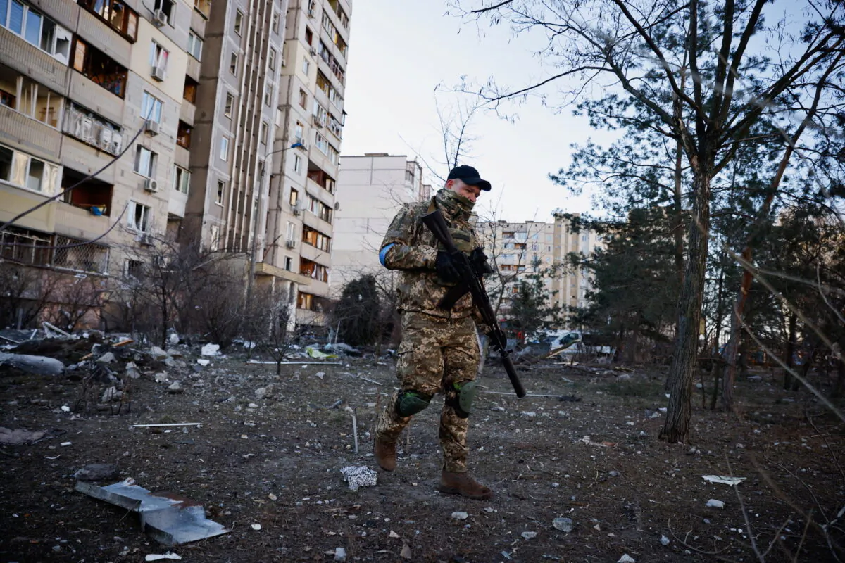 A member of the Ukrainian military surveys an area next to a residential building that was hit by an intercepted missile, in Kyiv, Ukraine, on March 17, 2022. (Thomas Peter/Reuters)