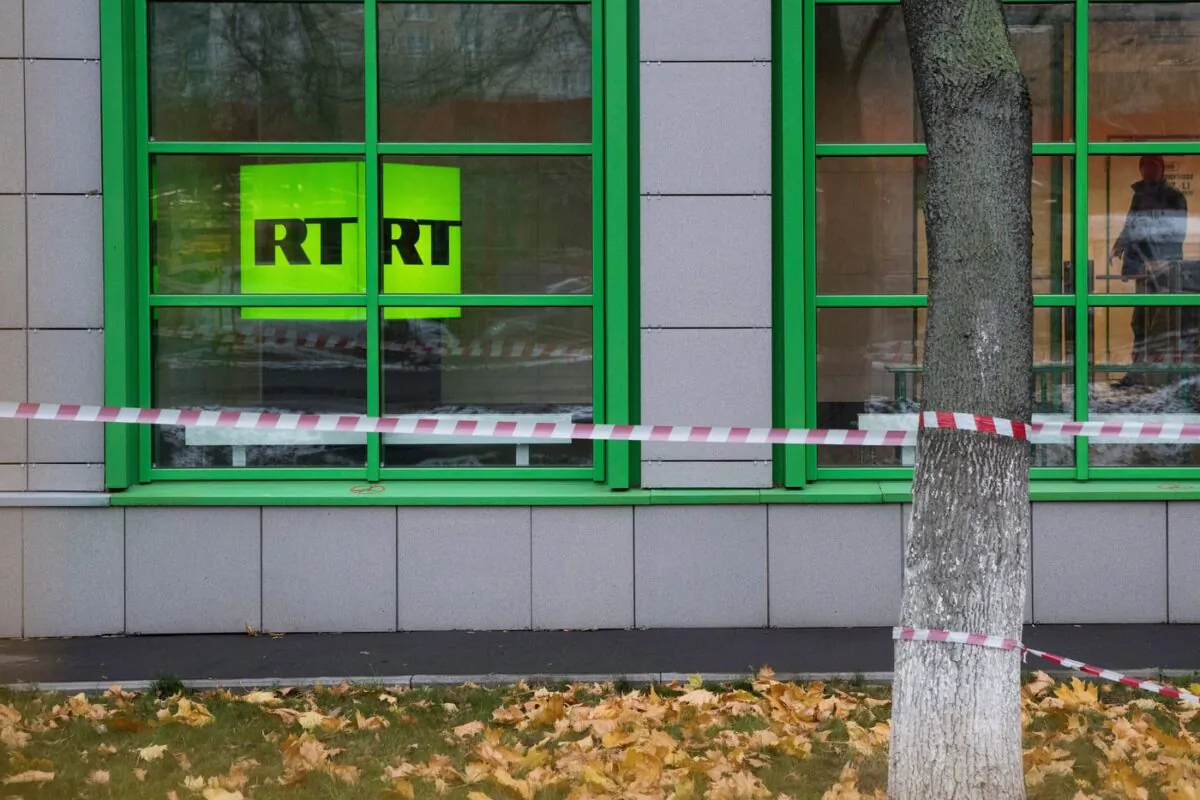 The logo for Russian state-owned television station RT is seen at the window of the company's office in Moscow, Russia on Oct. 27, 2017. (The Canadian Press/AP-Pavel Golovkin)