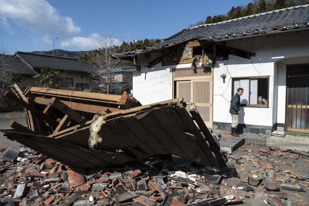 Sushi maker Akio Hanzawa walks in front of his damaged restaurant in Shiroishi, Miyagi prefecture on March 17, 2022, after a 7.3-magnitude earthquake jolted east Japan the night before. (Charly Triballeau/AFP via Getty Images)
