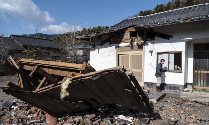 Sushi maker Akio Hanzawa walks in front of his damaged restaurant in Shiroishi, Miyagi prefecture on March 17, 2022, after a 7.3-magnitude earthquake jolted east Japan the night before. (Charly Triballeau/AFP via Getty Images)