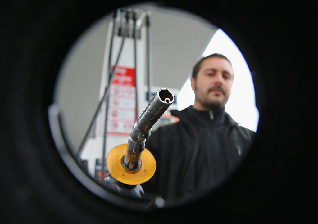 In this photo illustration, a man uses a fuel dispenser to fill his car up with petrol at a petrol station in Melbourne, Australia, on July 23, 2013. (Scott Barbour/Getty Images)