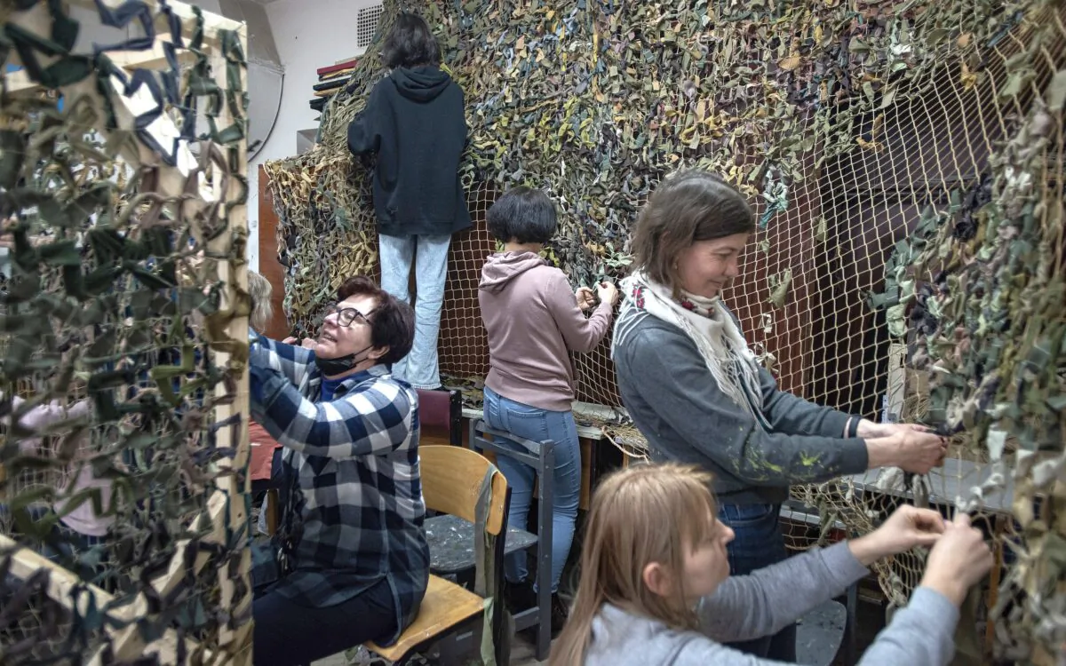 Women weave a camouflage net in Lviv, Ukraine, on March 16, 2022. Lviv has served as a stopover and shelter for the millions of Ukrainians fleeing the Russian invasion, either to the safety of nearby countries or the relative security of western Ukraine. (Alexey Furman/Getty Images)