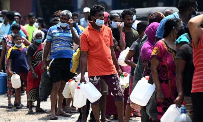 People stand in a line to buy kerosene oil for home use at a gas station in Colombo, Sri Lanka, on March 17, 2022. (Ishara S. Kodikara/AFP via Getty Images)