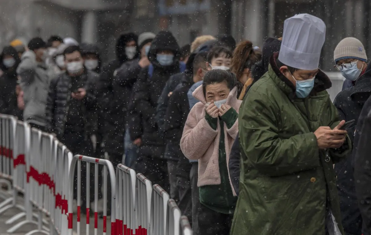 People wait in line to give a sample for a nucleic acid test for COVID-19 at a testing site in Beijing, China on March 17, 2022. (Kevin Frayer/Getty Images)