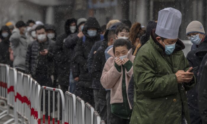 People wait in line to give a sample for a nucleic acid test for COVID-19 at a testing site in Beijing, China on March 17, 2022. (Kevin Frayer/Getty Images)