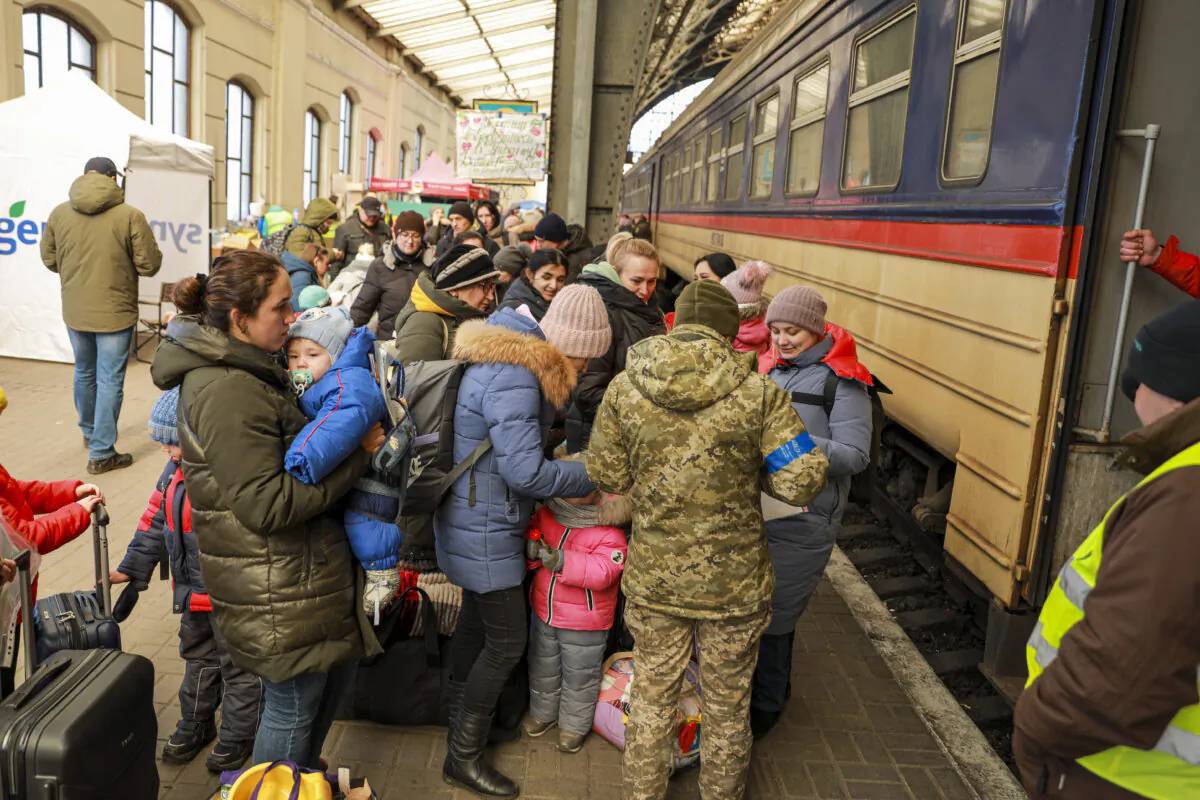 Ukrainian refugees prepare to board a train to Poland at the train station in Lviv, Ukraine, on March 18, 2022. (Charlotte Cuthbertson/The Epoch Times)