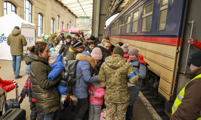 Ukrainian refugees prepare to board a train to Poland at the train station in Lviv, Ukraine, on March 18, 2022. (Charlotte Cuthbertson/The Epoch Times)