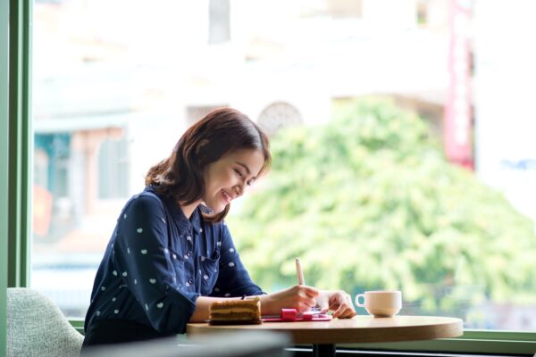 woman writing in cafe