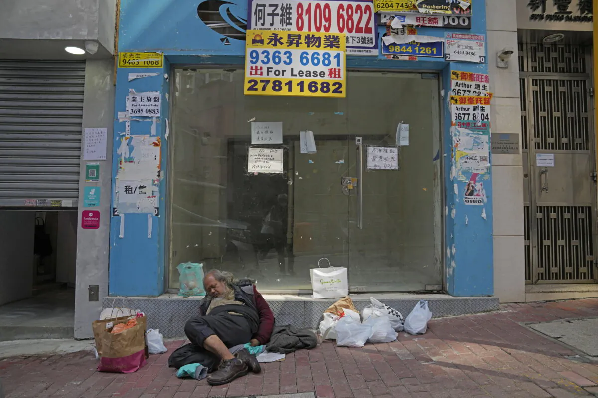 A man sleeps in front of a store for lease in the Central district in Hong Kong on March 15, 2022. (Kin Cheung/AP Photo)