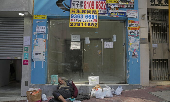 A man sleeps in front of a store for lease in the Central district in Hong Kong on March 15, 2022. (Kin Cheung/AP Photo)