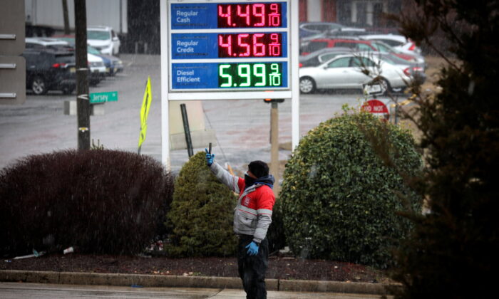 A worker takes pictures of gasoline prices at a gas station in Jersey City, New Jersey, U.S., March 9, 2022. (REUTERS/Mike Segar)