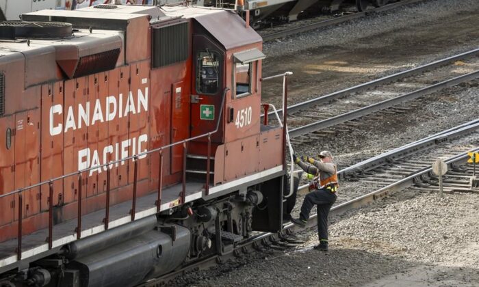An employee boards a Canadian Pacific Railway locomotive at a yard in Calgary on March 18, 2022. (The Canadian Press/Jeff McIntosh)