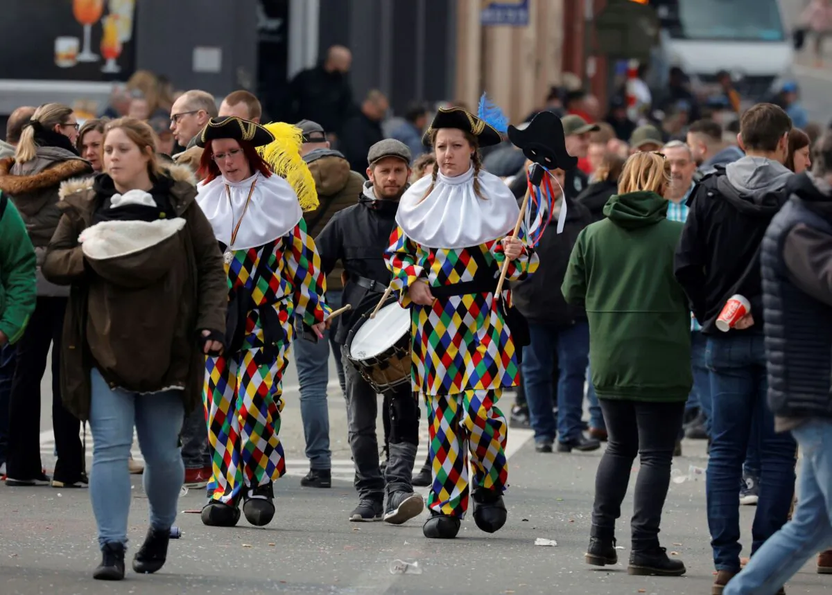 People walk home on a street, after an incident at a carnival, in Strepy-Bracquenies, Belgium, on March 20, 2022. (Olivier Matthys/AP Photo)