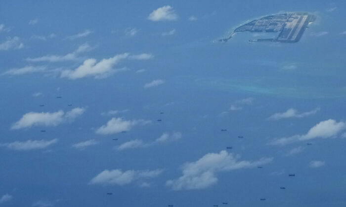 Boats beside Chinese structures and buildings on the man-made Fiery Cross Reef at the Spratlys group of islands in the South China Sea on March 20, 2022. (Aaron Favila/AP Photo)