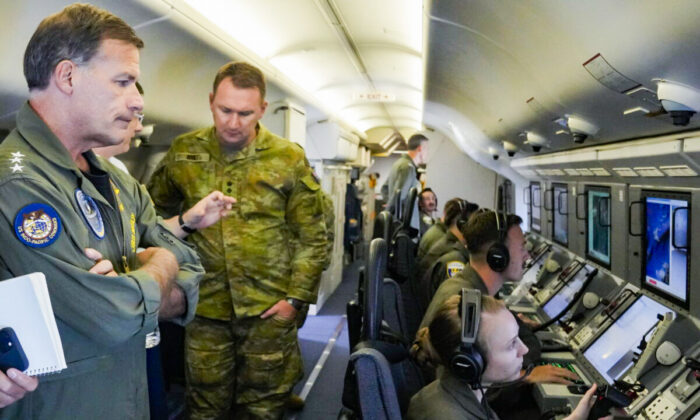 Adm. John C. Aquilino (L), commander of the U.S. Indo-Pacific Command, looks at videos of Chinese structures and buildings on board a U.S. P-8A Poseidon reconnaissance plane flying at the Spratlys group of islands in the South China Sea, on March 20, 2022. (Aaron Favila/AP Photo)