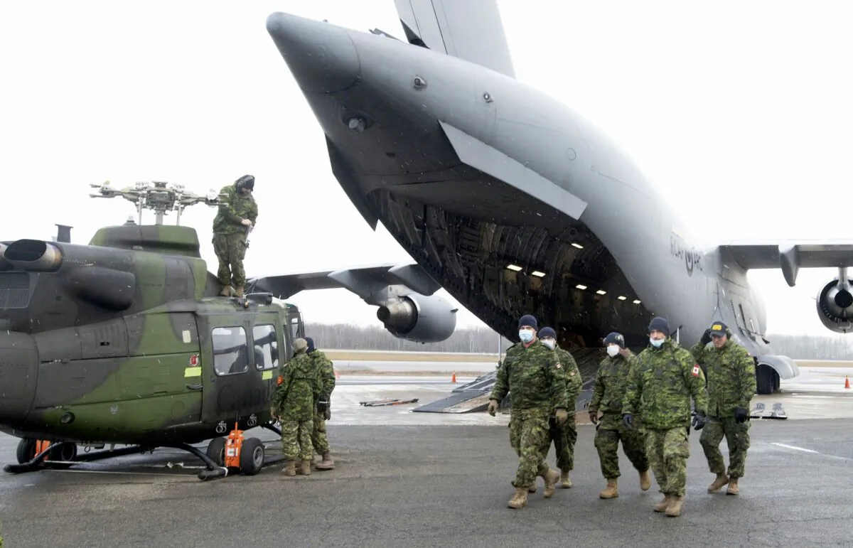 The Canadian Armed Forces prepare to load a helicopter onto a C-177 Globemaster III in Quebec City as part of sending relief to the flooded areas of British Columbia, on Nov. 19, 2021. (The Canadian Press/Jacques Boissinot)