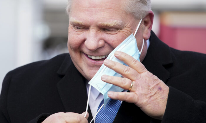 Ontario Premier Doug Ford smiles as he removes his mask before making an announcement during a press conference in Toronto on March 3, 2022. (The Canadian Press/Nathan Denette)