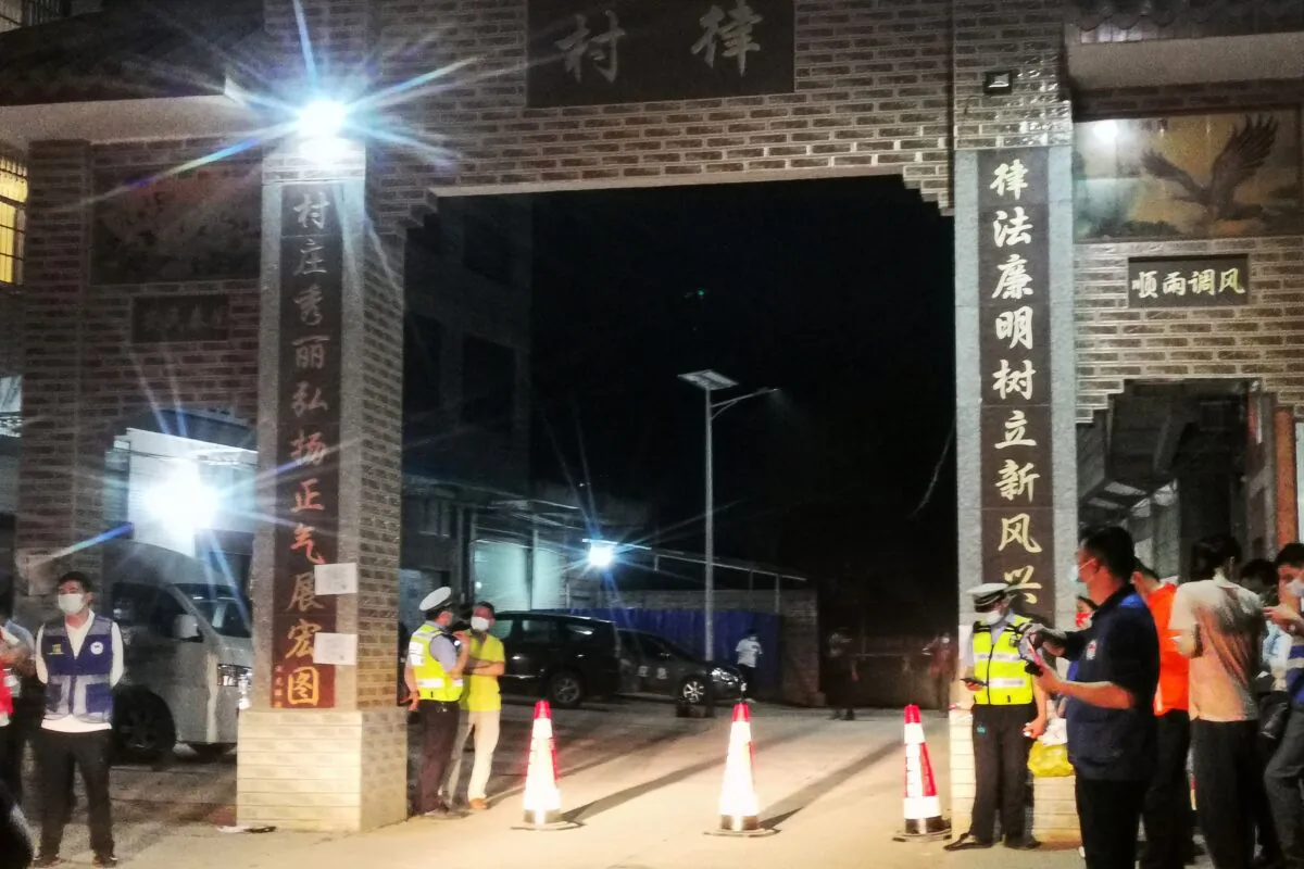 Police officers stand guard at the entrance to a village near the site of a plane crash in Tengxian county, Wuzhou city, in Guangxi Province on March 21, 2022.(-/AFP via Getty Images)