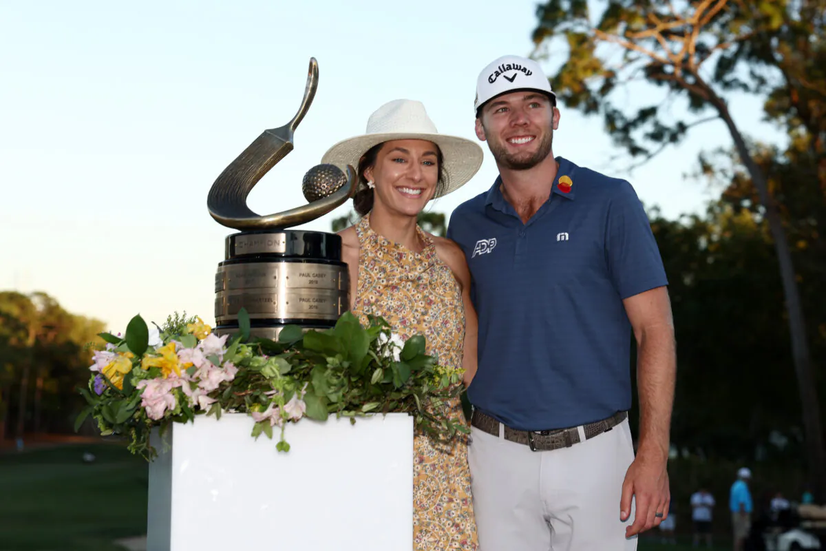 Sam Burns of the United States celebrates with his wife Caroline Campbell and the trophy after defeating Davis Riley of the United States during a playoff in the final round of the Valspar Championship on the Copperhead Course at Innisbrook Resort and Golf Club, in Palm Harbor, Florida, on March 20, 2022. (Douglas P. DeFelice/Getty Images)