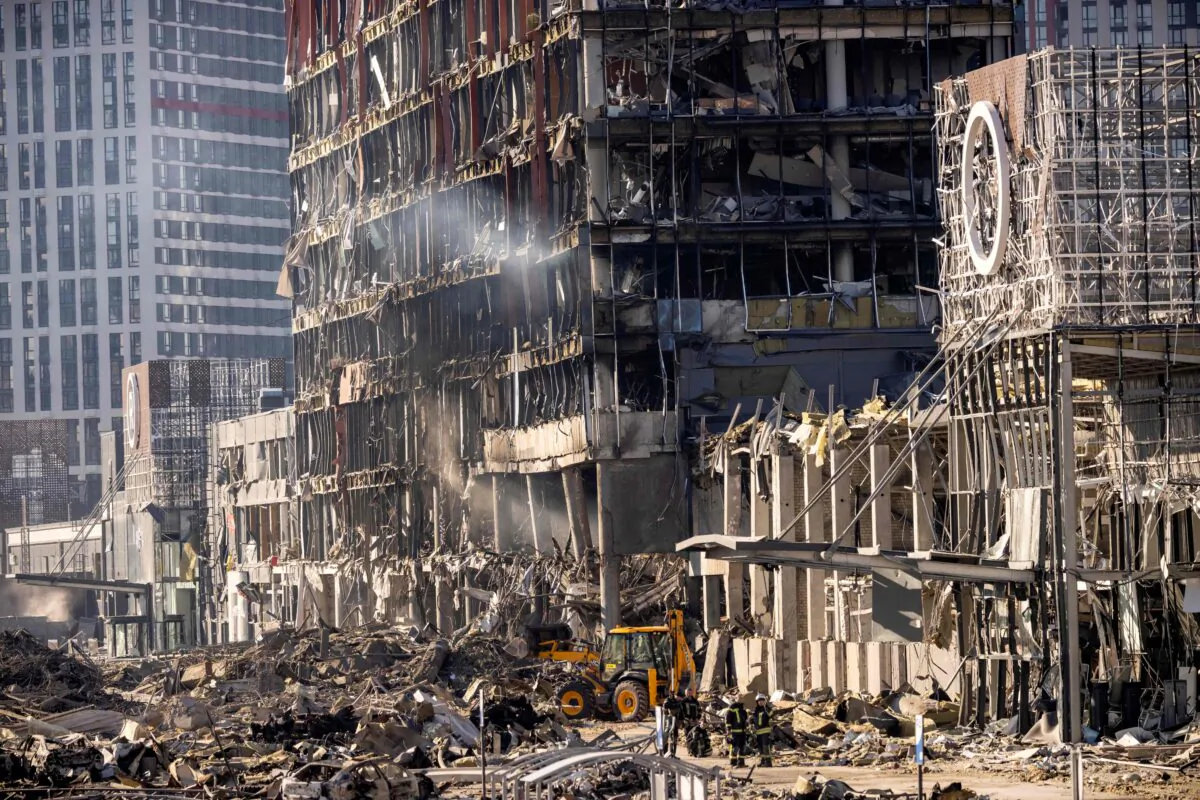 Ukrainian firefighters work amid the rubble of the Retroville shopping mall, a day after it was shelled by Russian forces in a residential district in the northwest of the Ukrainian capital Kyiv, on March 21, 2022. (Fadel Senna/AFP via Getty Images)